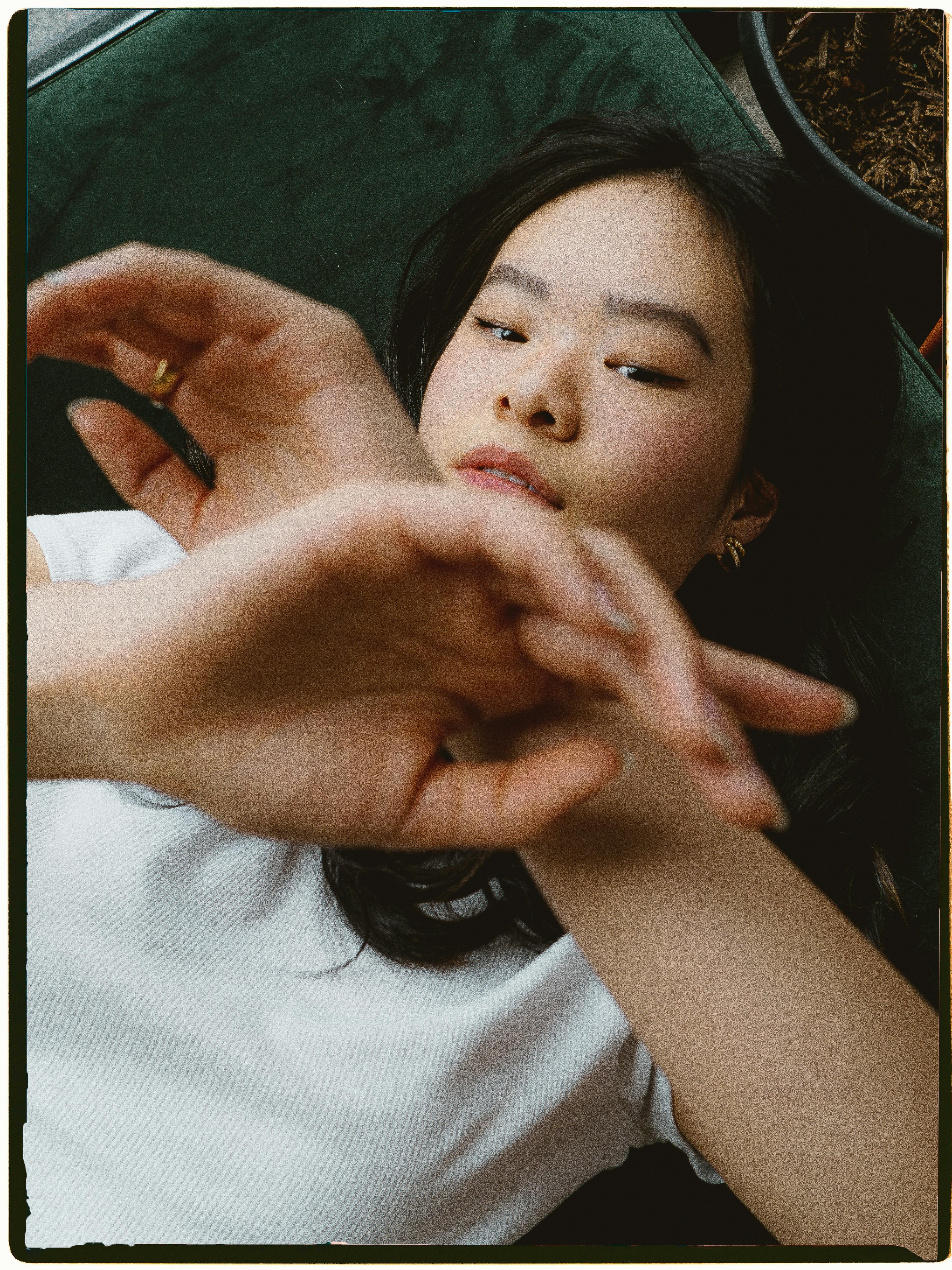 a woman laying down with her hands in the air