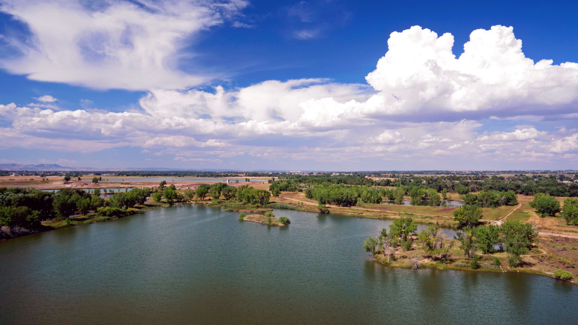 Scenic aerial view of a serene lake surrounded by lush greenery in Fort Collins, Colorado.