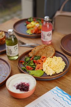 Delicious breakfast plate featuring scrambled eggs, avocado, and fresh vegetables. Perfect for food lovers.
