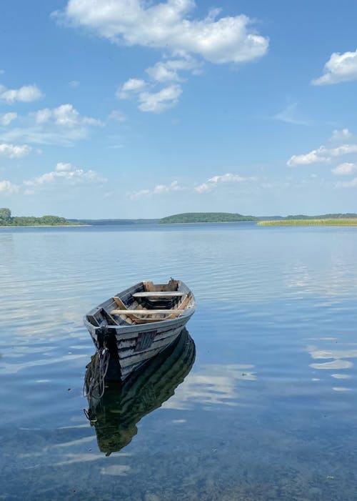 A Wooden Boat on a Lake under a Blue Sky