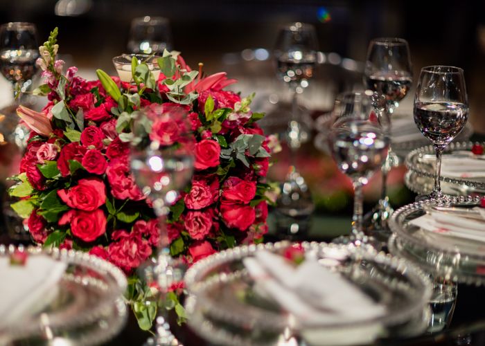 Table setting with red roses and crystal glassware