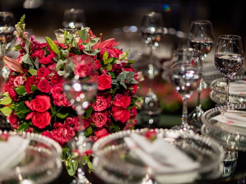 Table setting with red roses and crystal glassware