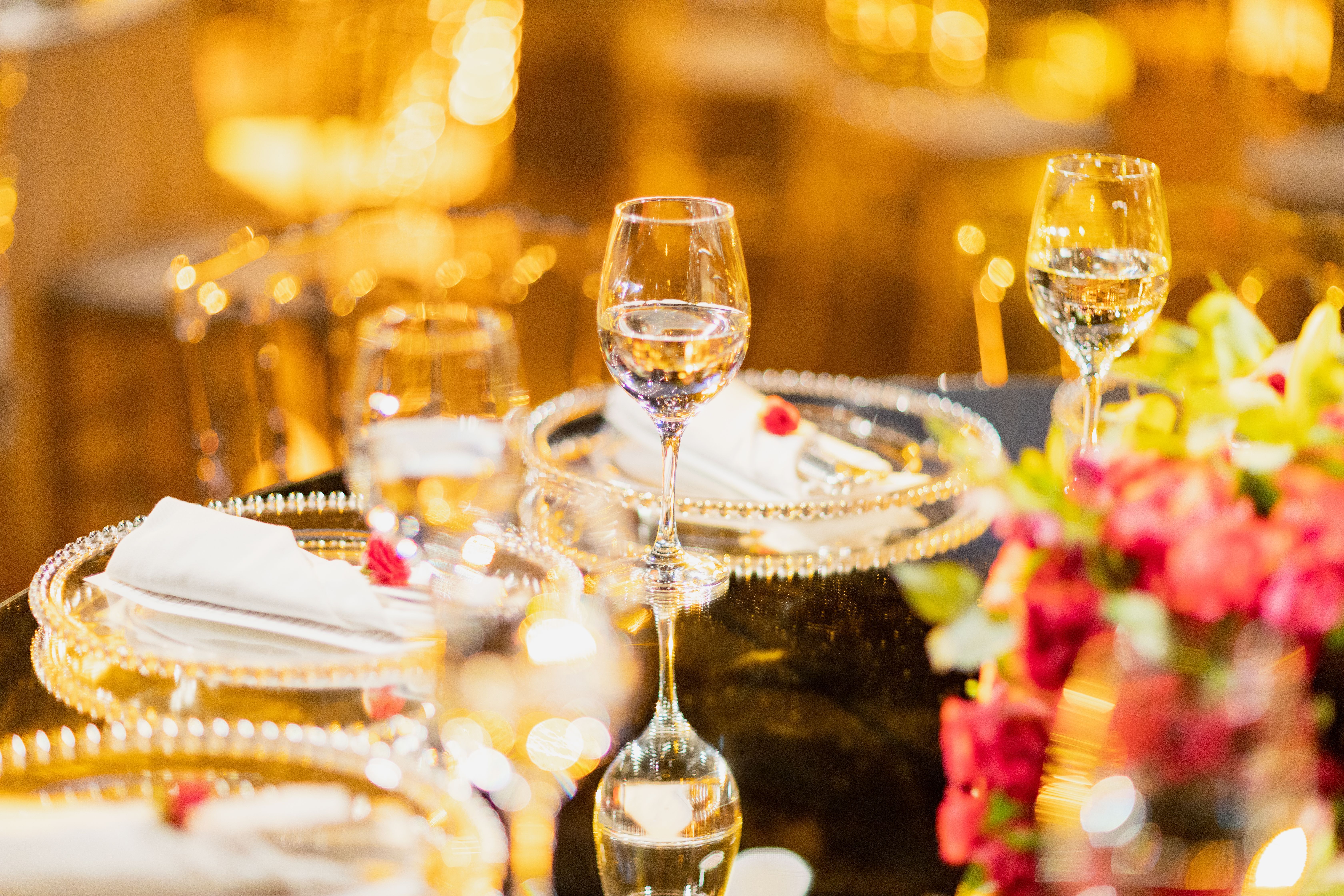 Luxurious wedding table setting with crystal wine glasses and floral decor, capturing elegance and sophistication.