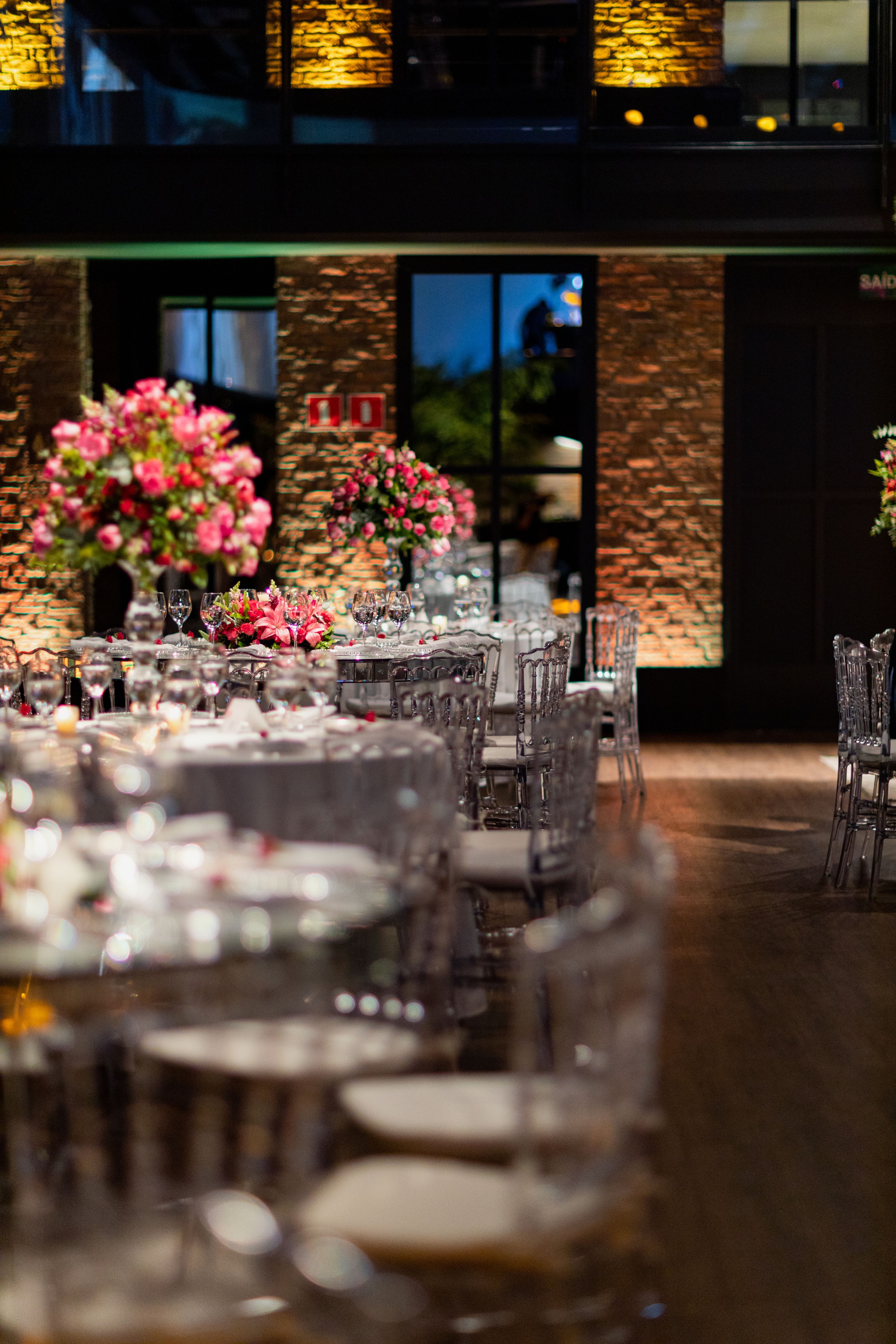 Um ambiente de jantar luxuoso com arranjos florais elegantes e iluminação ambiente. Ideal para eventos sofisticados.