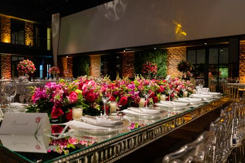 Free Luxurious wedding reception table with pink flower arrangements and fine dining setup. Stock Photo