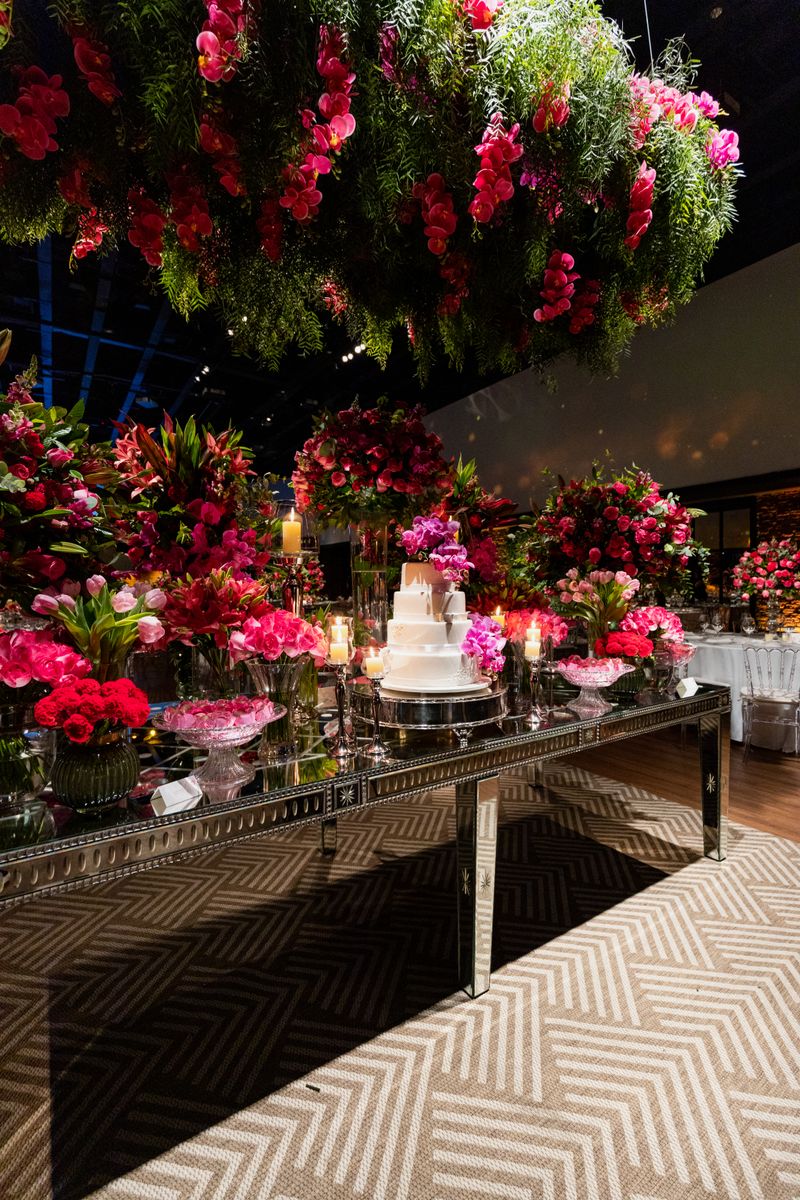 Mesa com bolo de casamento entre flores