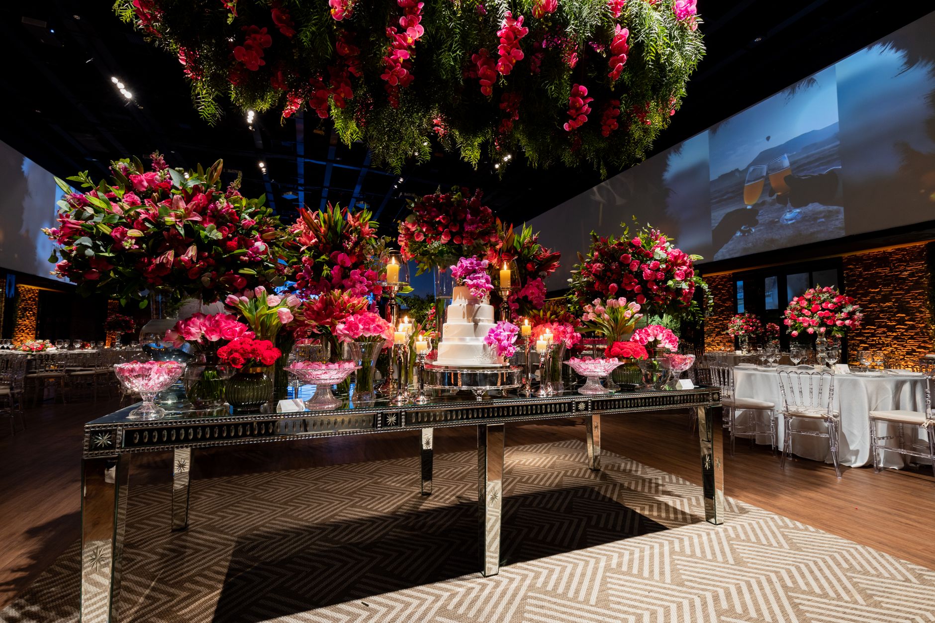 Luxurious wedding reception setup featuring a cake and vibrant floral arrangements.