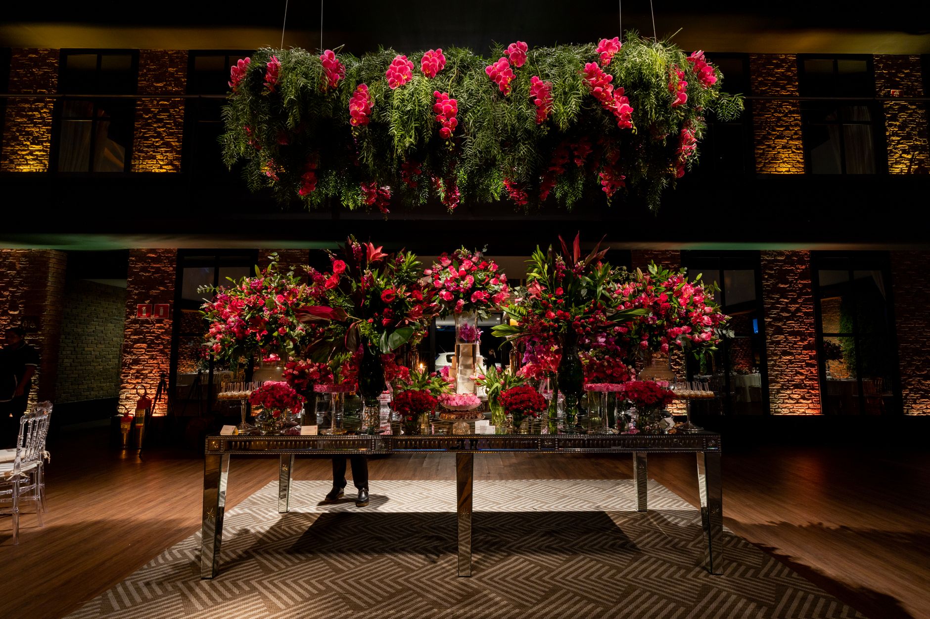 Exquisite wedding reception with elegant table setting and lush pink flower arrangements.
