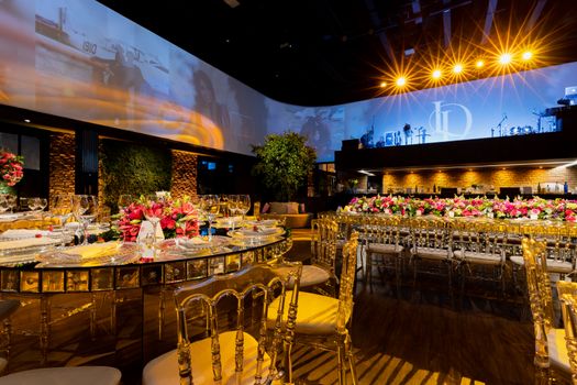 Luxurious indoor wedding venue with elegant table settings and warm lighting.