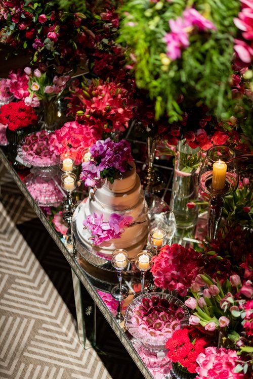 Free Stunning wedding cake surrounded by vibrant flowers and candles, exuding elegance. Stock Photo