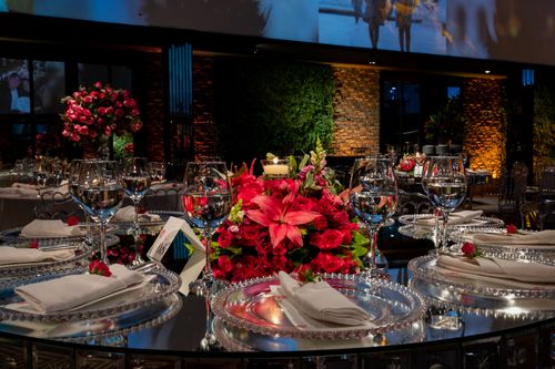 Free Luxurious wedding dining setup featuring elegant cutlery, glassware, and a pink floral centerpiece. Stock Photo