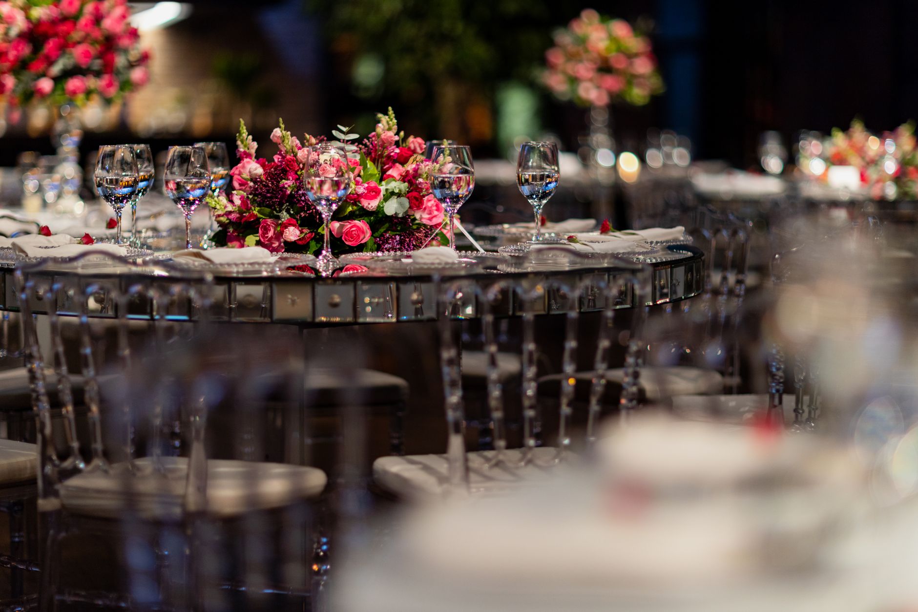 Luxurious wedding reception table setup with pink floral centerpiece and glassware.