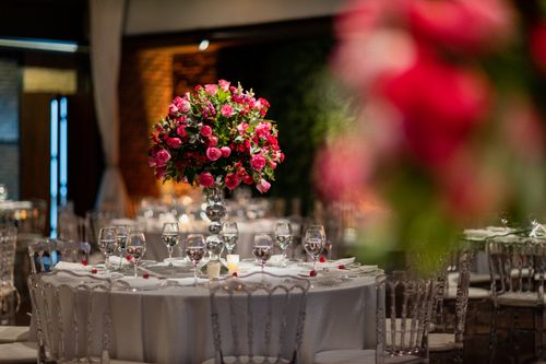 Free Stunning wedding venue showcasing a vibrant pink rose centerpiece on a beautifully set table. Stock Photo