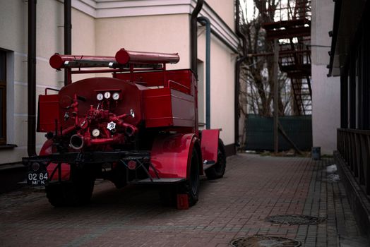 Retro ZIS-5 fire truck parked in a Minsk alleyway, showcasing vintage machinery.