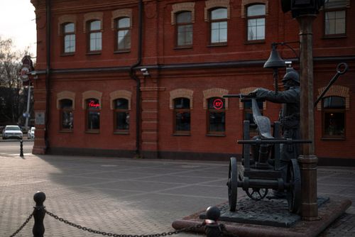 Free Urban scene with a statue of a fireman near a historic brick building in Minsk. Stock Photo
