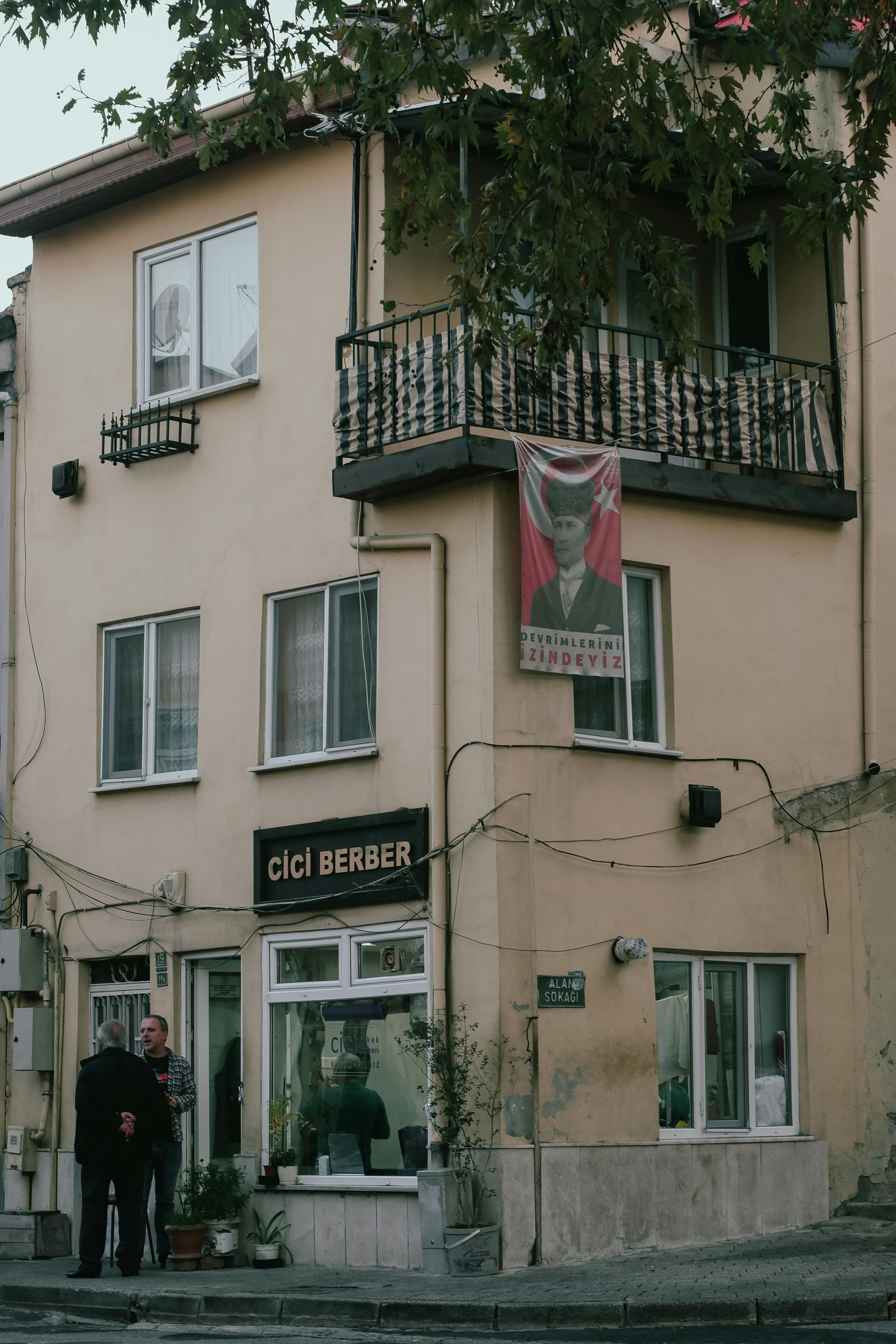 Free Street view of an urban residential building with a balcony and a visible poster. Stock Photo