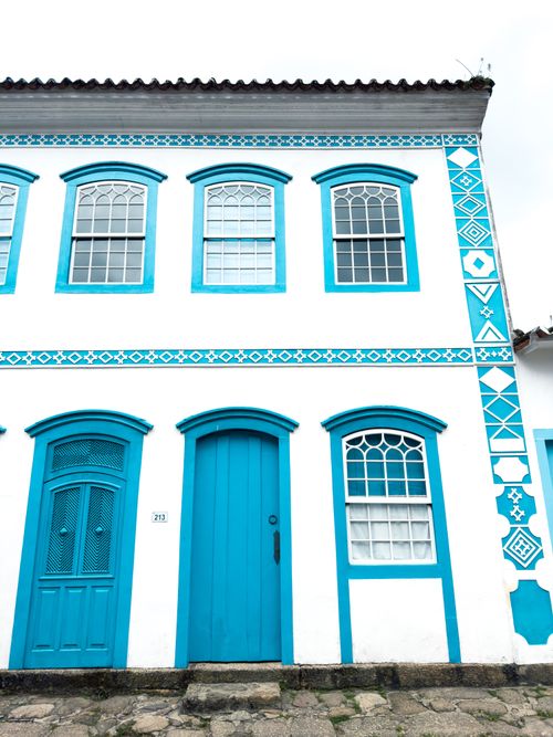 Free Bright blue and white colonial building facade with decorative windows and doors. Stock Photo