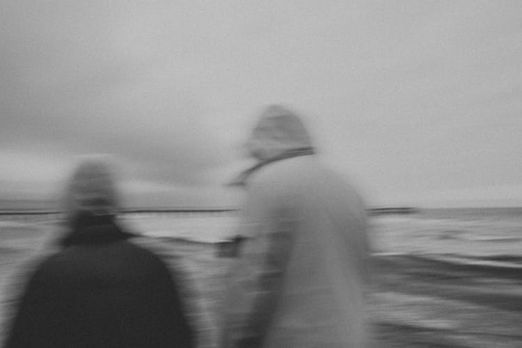 Blurred People Walking On Sea Shore