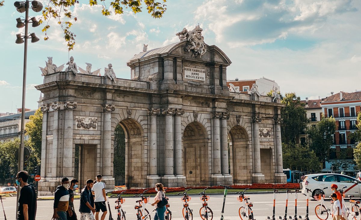 The Alcala Gate in Madrid with passers by under a clear sky