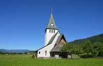 蓝天下的绿色景观中，风景如画的乡村教堂体现了宁静的氛围