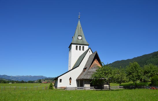 蓝天下的绿色景观中，风景如画的乡村教堂体现了宁静的氛围