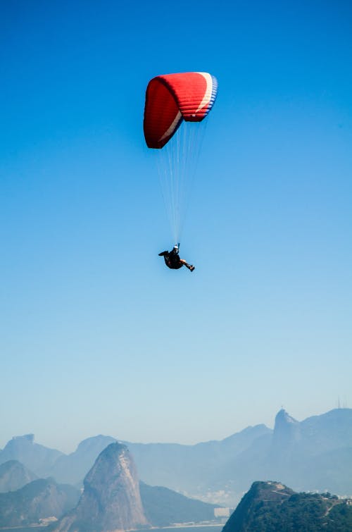 Roter Weißer Fallschirm Auf Der Spitze Der Berge Während Des Tages