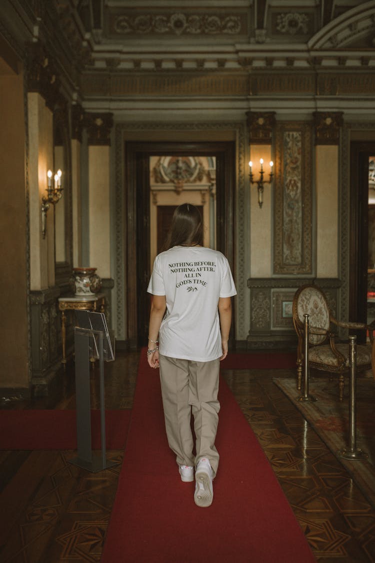 Woman In T-Shirt Walking In Museum