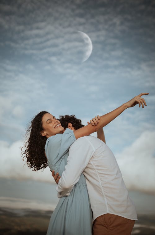 Moon Rising over an Embracing Couple