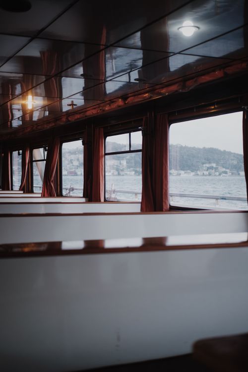 Free Empty ferry interior with windows showing scenic water view, offering travel and transportation theme. Stock Photo