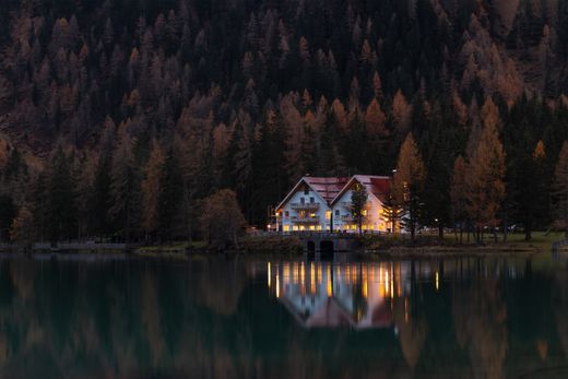 Timber lakeside house mirrored in still water at dusk — photo by eberhard grossgasteiger on Pexels