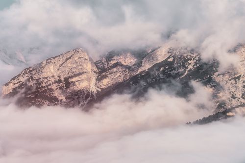 Free A serene winter landscape of the Dolomites mountains enveloped by mist and clouds, creating a dramatic and ethereal scene. Stock Photo