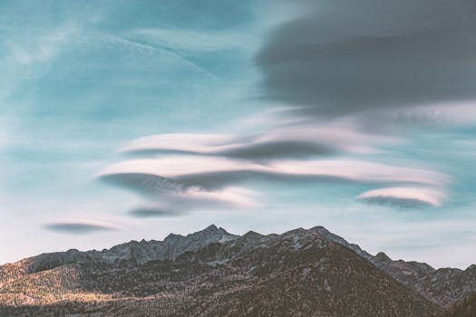 Captivating mountain scene featuring dramatic cloud formations against a vibrant sky.