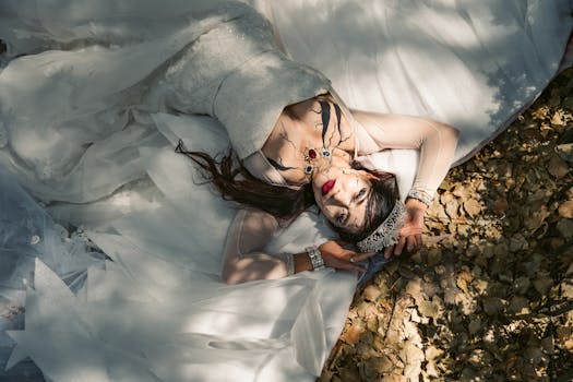 A woman in Halloween makeup and a wedding dress lies on leaves in a Mexico City park.