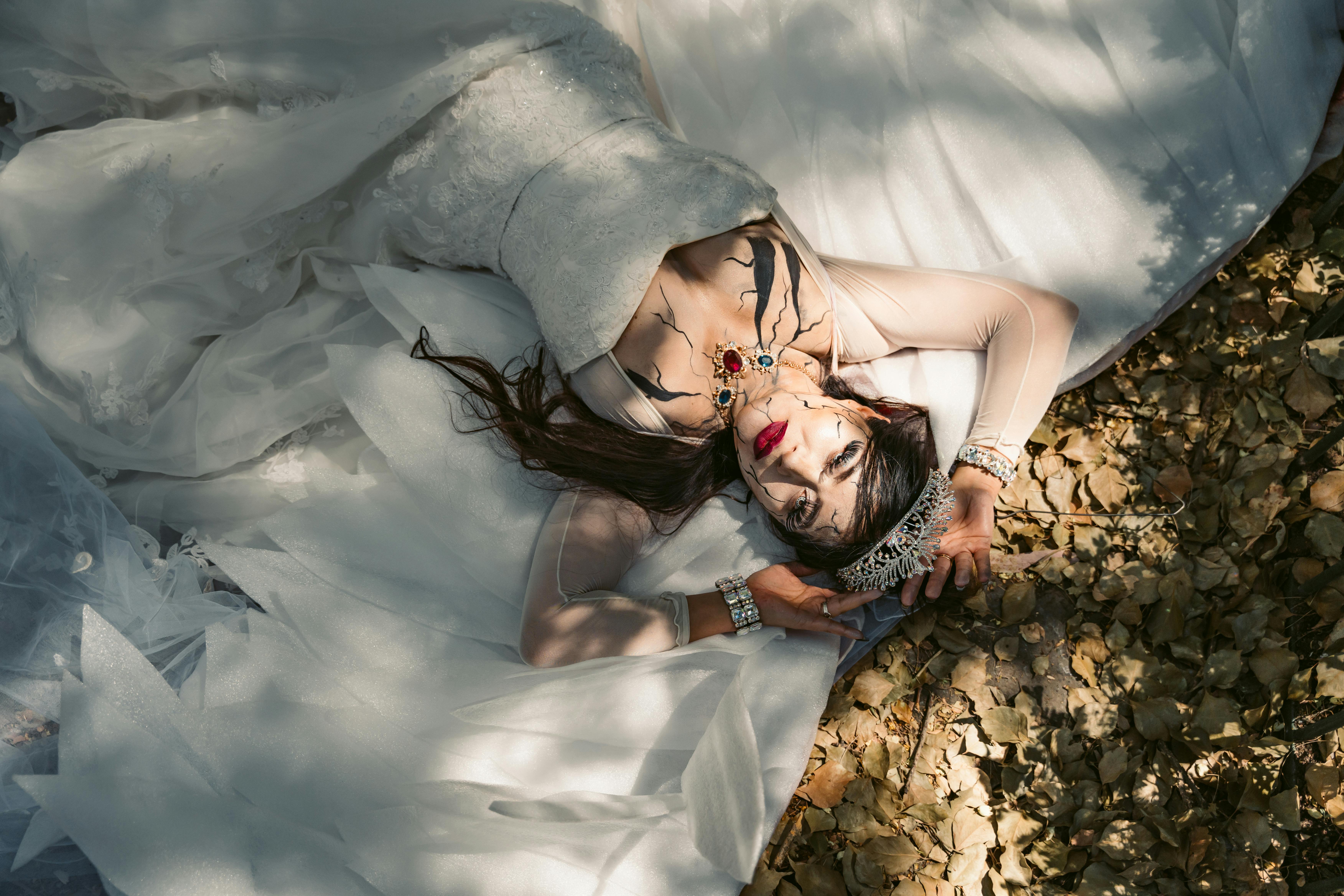 Free Woman in Halloween Makeup and a Bride Costume Lying on the Ground Stock Photo