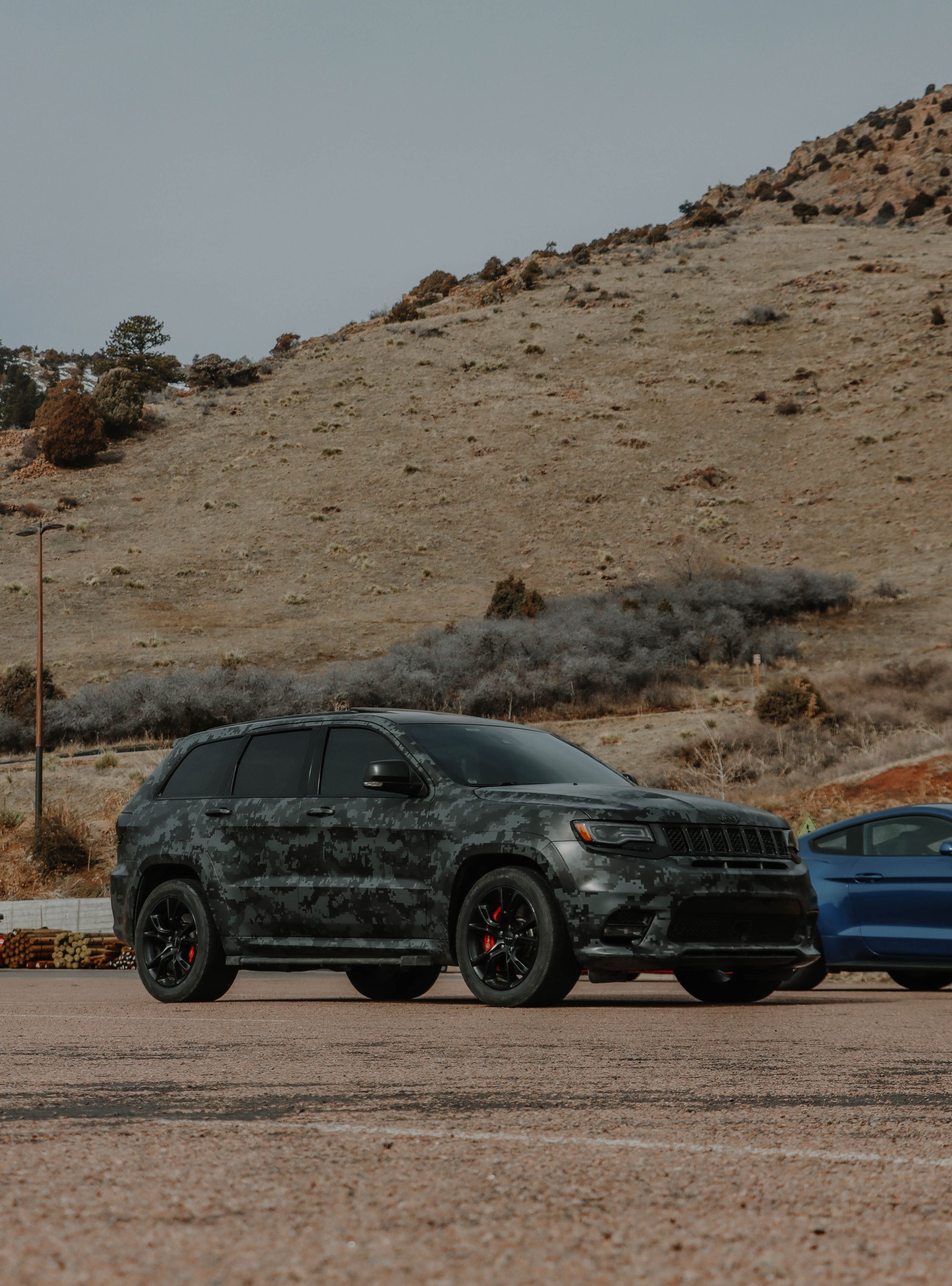 Shows a Jeep Grand Cherokee with aggressive styling and red brake calipers in a desert setting, closely matching the…