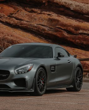 A luxurious silver AMG GT sports car parked in a desert landscape.