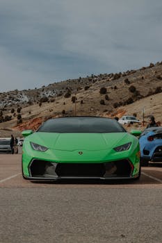 A striking green Lamborghini Huracan parked in a scenic mountainous terrain, showcasing luxury amidst nature.