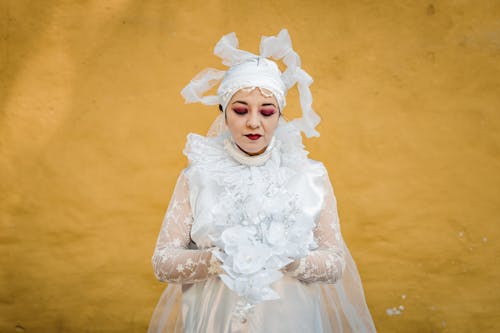 Bride Standing on the Background of a Yellow Wall