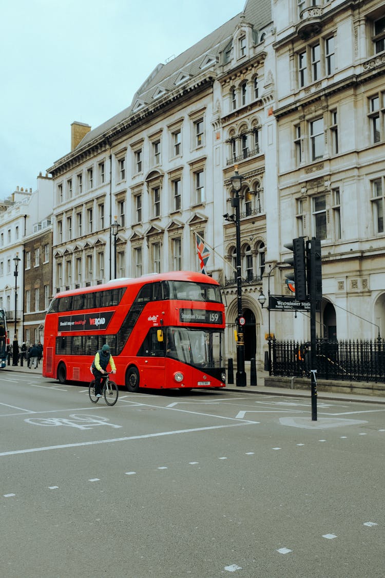 Red Bus And Cyclist On Street In Town In UK