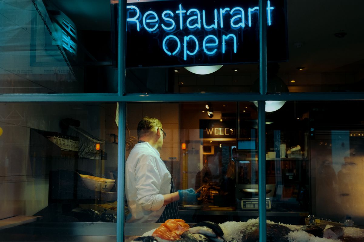 الامتثال القانوني قبل نشر الروبوت Chef behind a window with a neon Restaurant Open sign