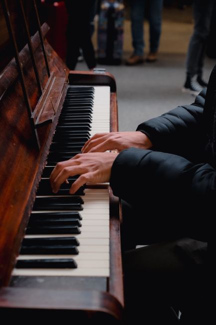 A detailed view of hands playing a piano, emphasizing the musical performance.