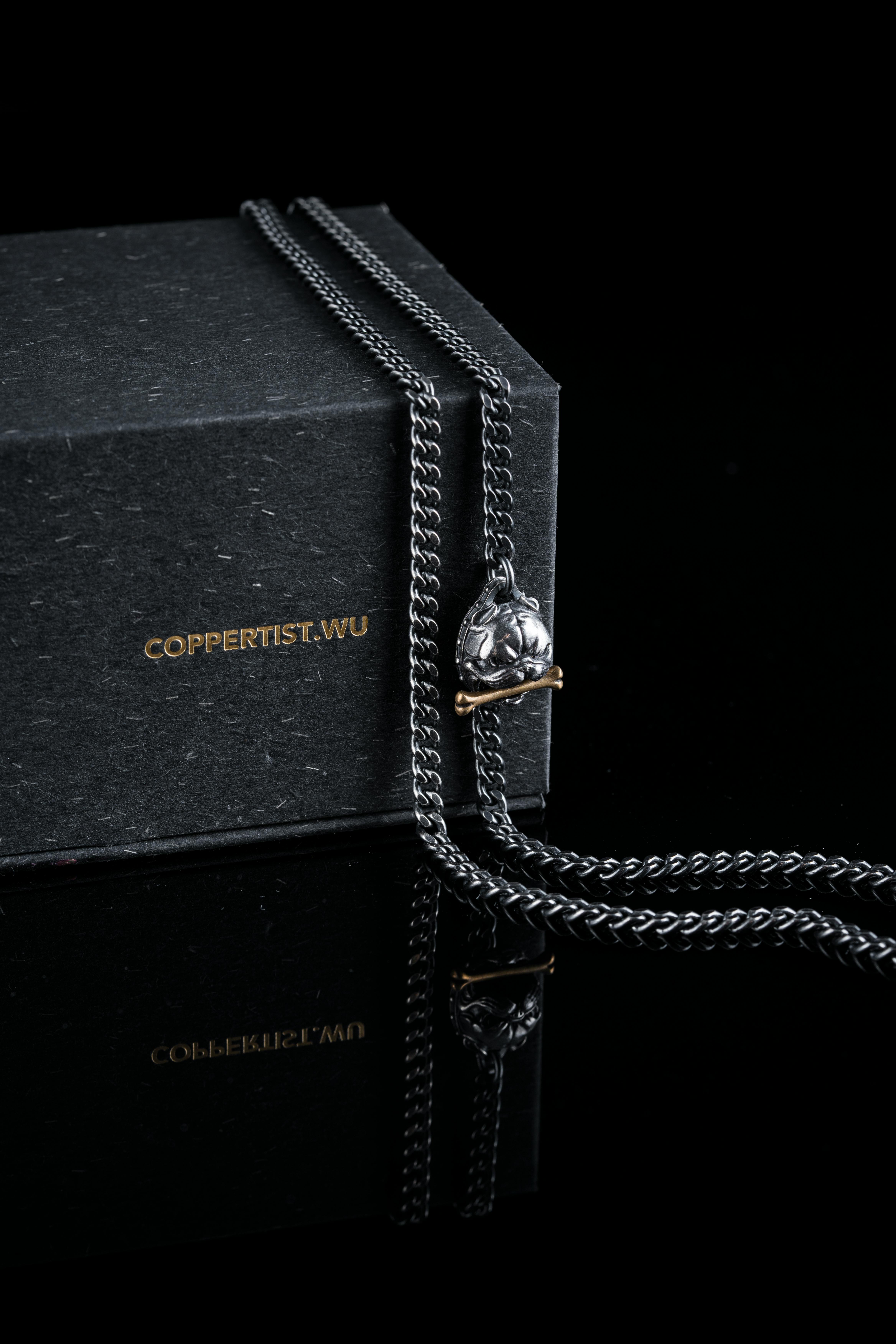 Close-up of a stylish black necklace displayed on a COPPERTIST.WU gift box.