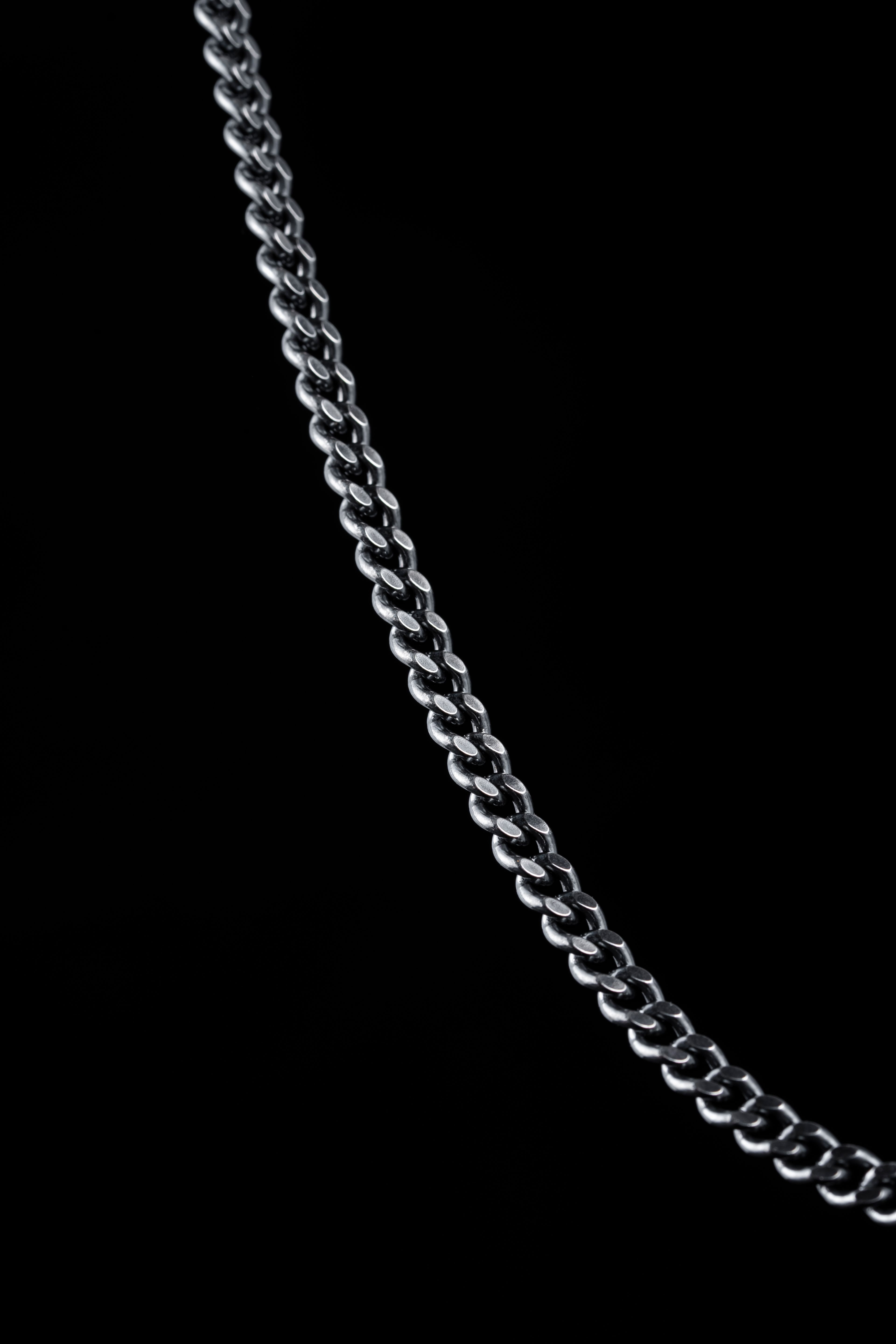 Close-up of a sterling silver chain against a dark background