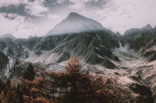 бесплатная Заснеженные горы под пасмурным небом Стоковое фото
