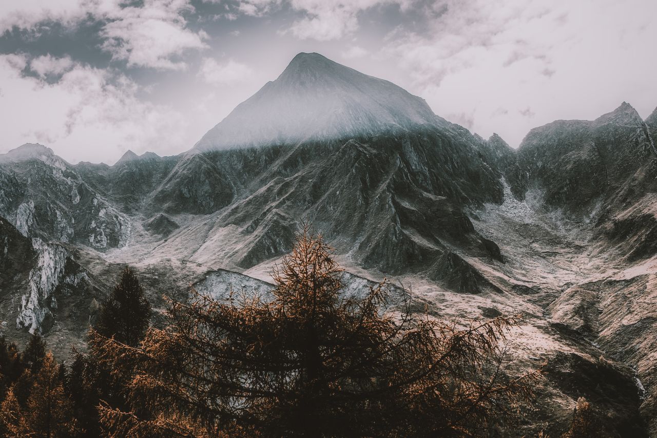 majestic mountain peak under a bright cloudy sky showcasing a dramatic