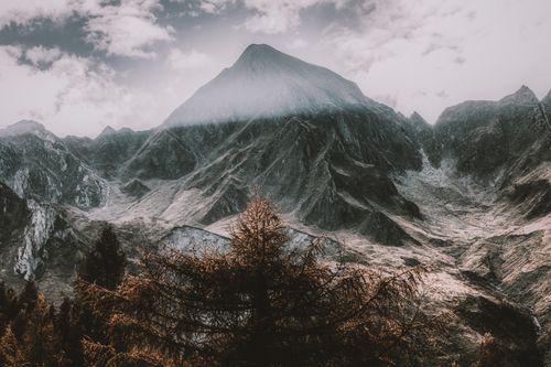 Free Majestic mountain peak under a bright, cloudy sky, showcasing a dramatic winter landscape. Stock Photo