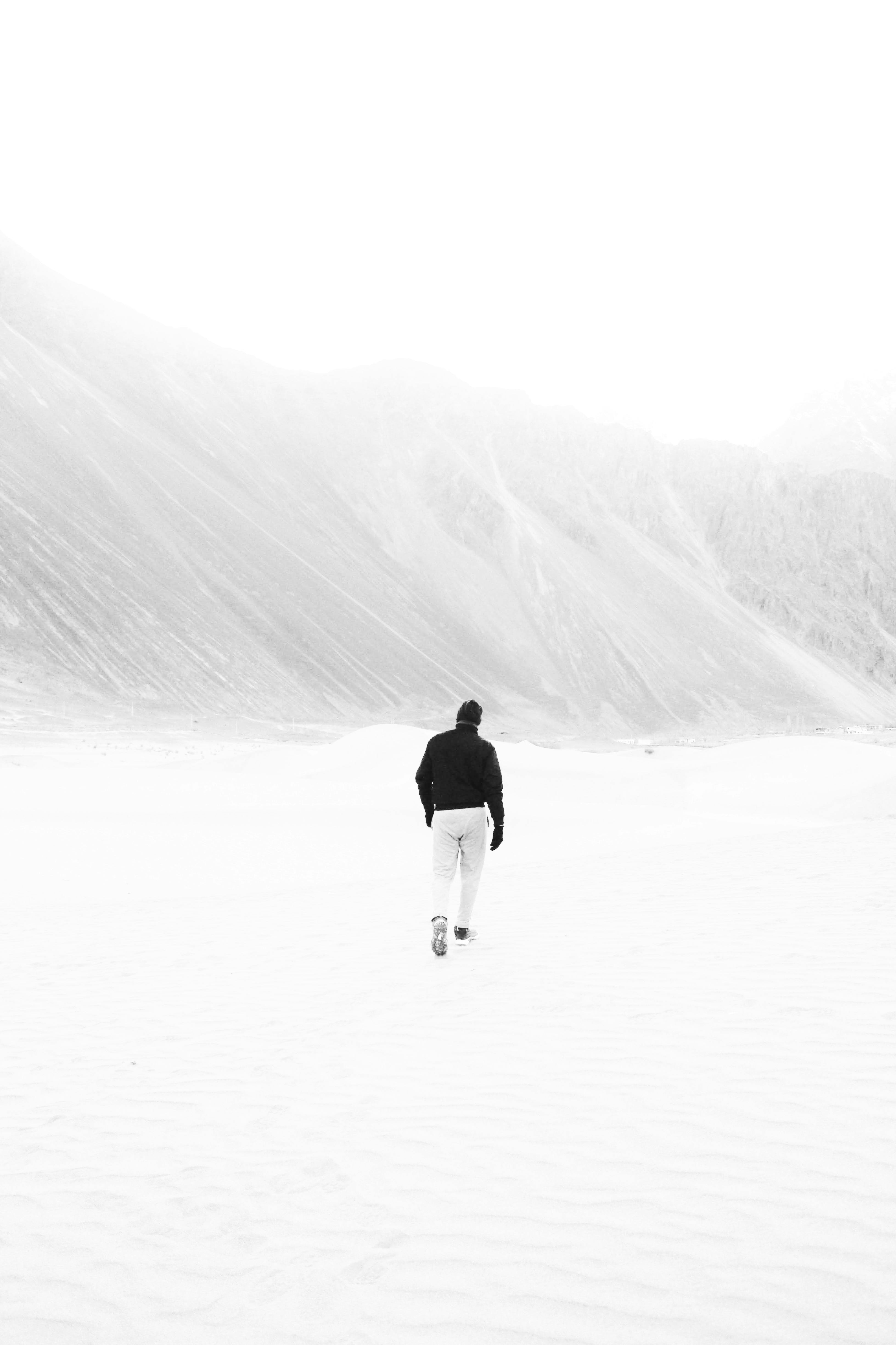 Man Walking on Desert in Black and White ยท Free Stock Photo