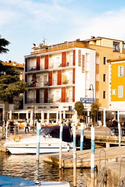 Charming lakeside hotel and boats at Iseo, Italy capture vibrant urban coastal life.