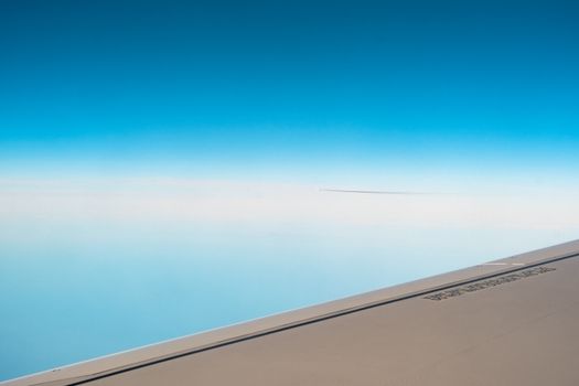 Stunning view from airplane window showcasing the wing and vast blue sky.
