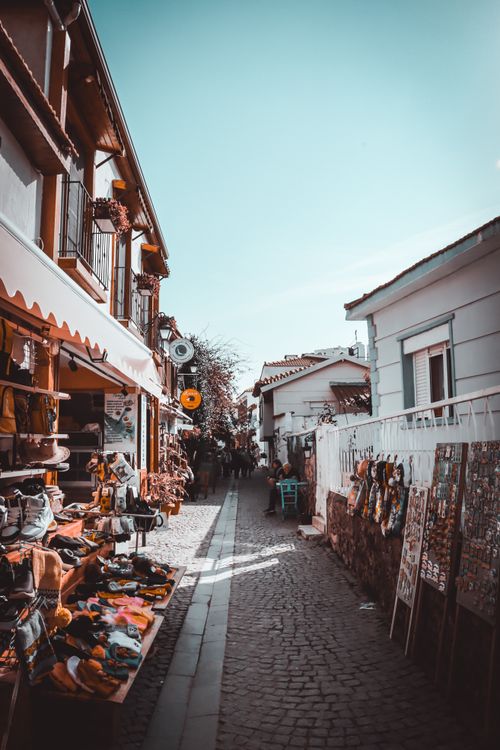 Free A picturesque alleyway with market stalls and merchandise in a quaint European town. Stock Photo